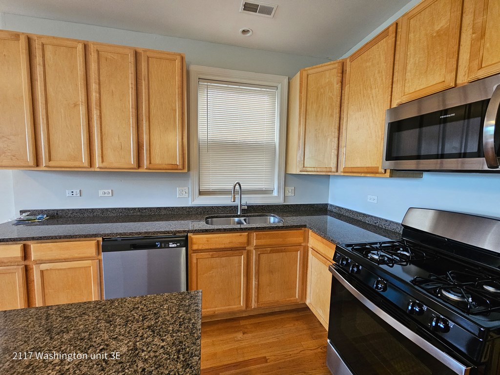 a kitchen with wooden cabinets and granite counter tops