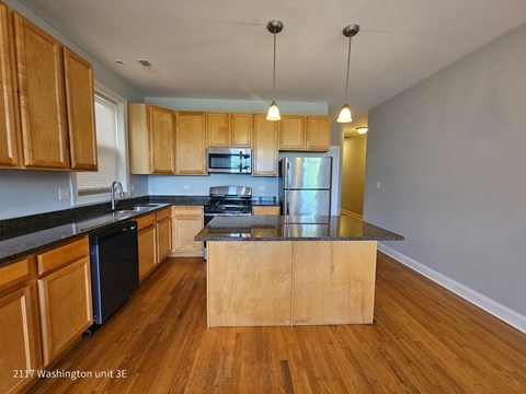 an empty kitchen with wooden cabinets and a counter top