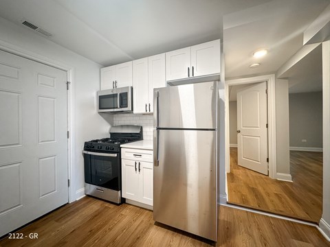 A kitchen with a stainless steel refrigerator, oven, and microwave.