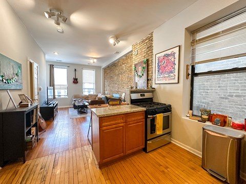 A kitchen with a stove top oven and a refrigerator.