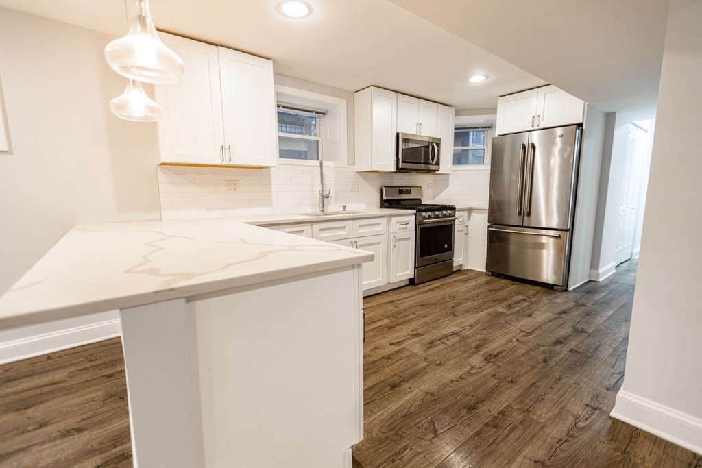A kitchen with white cabinets and a wooden island.