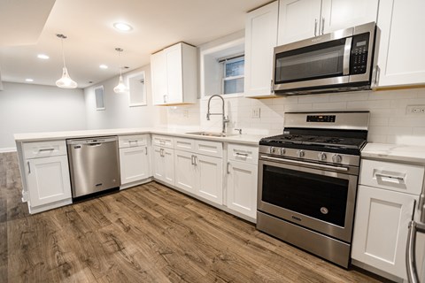 A kitchen with white cabinets and stainless steel appliances.