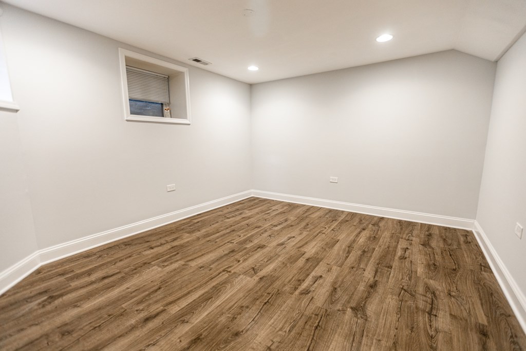 A room with wooden flooring and a small window.
