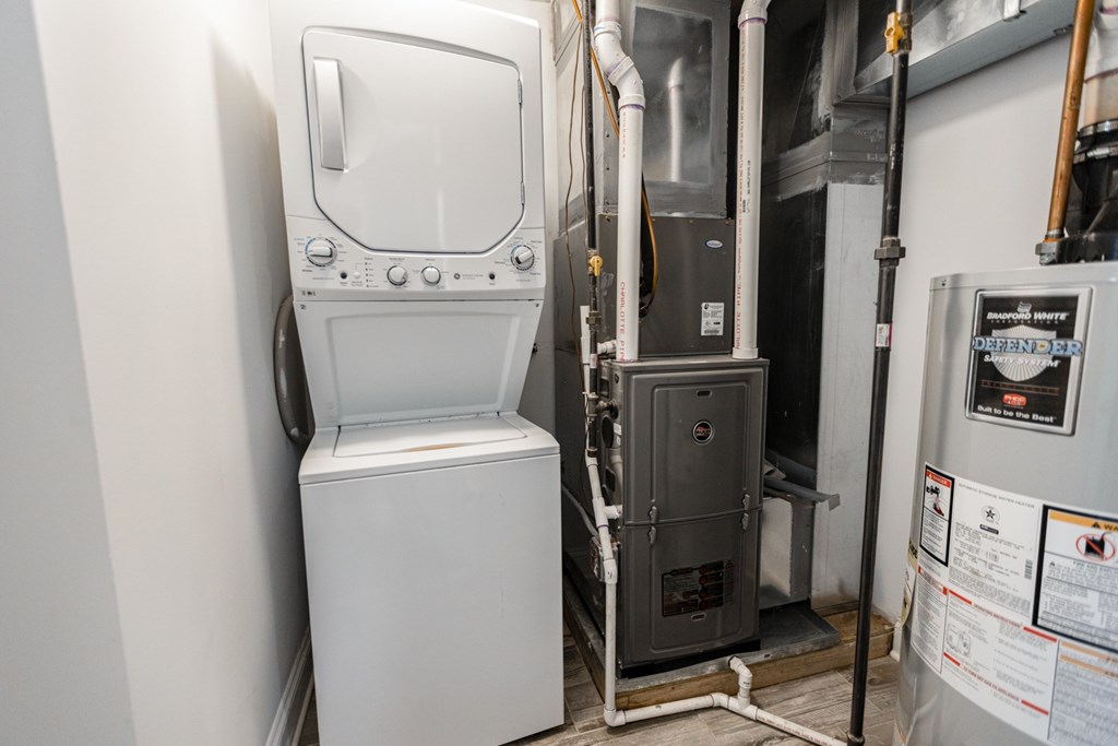 A white tankless water heater sits next to a wall.