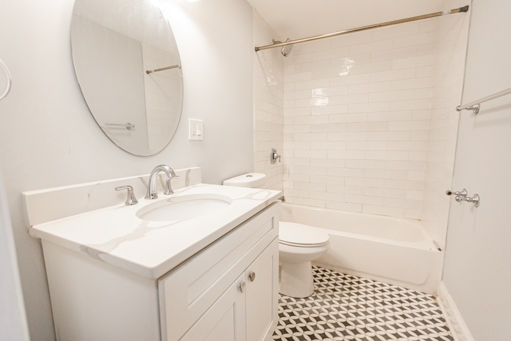 A white bathroom with a sink, toilet and bathtub.
