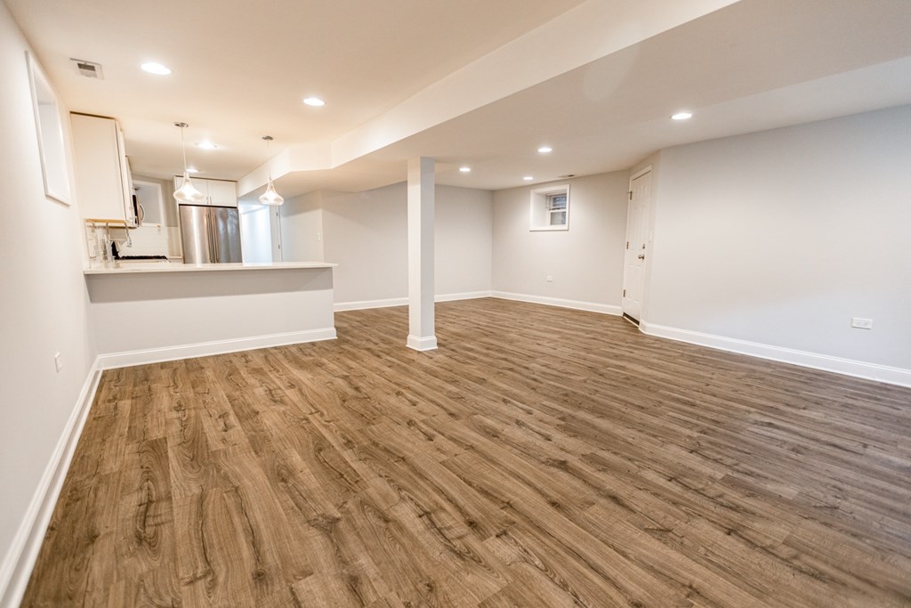 A room with wooden flooring and white walls.