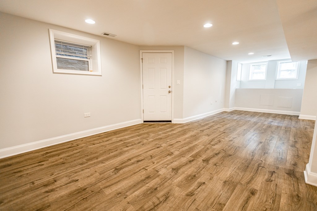 A room with wooden flooring and a white door.