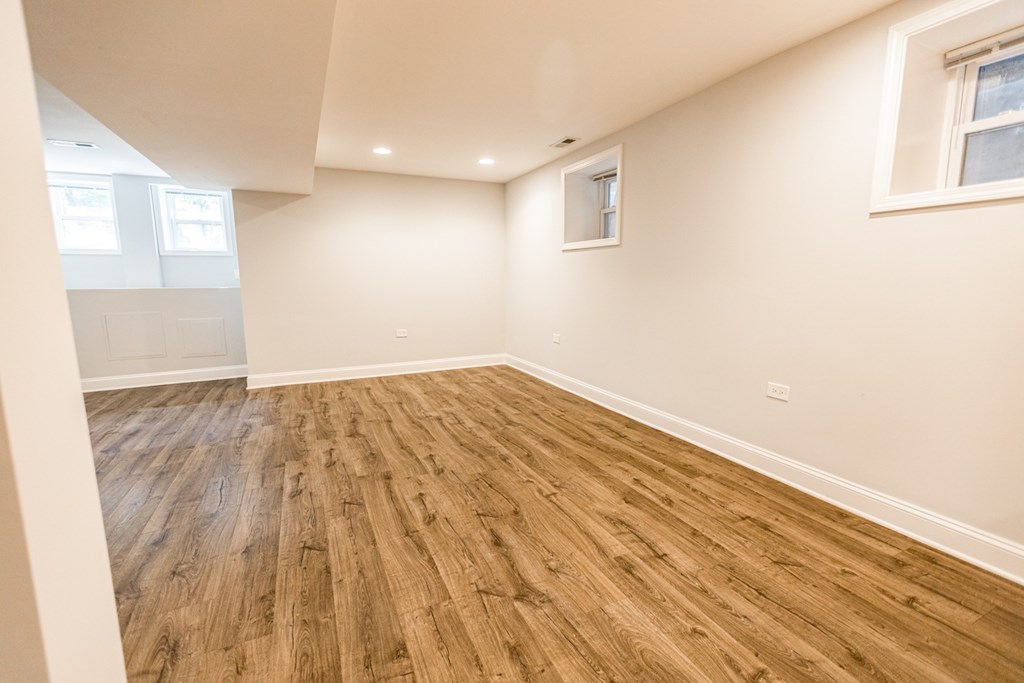 A room with wooden flooring and a window.