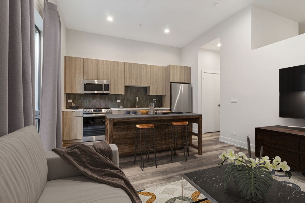 a kitchen with a large center island next to a living room