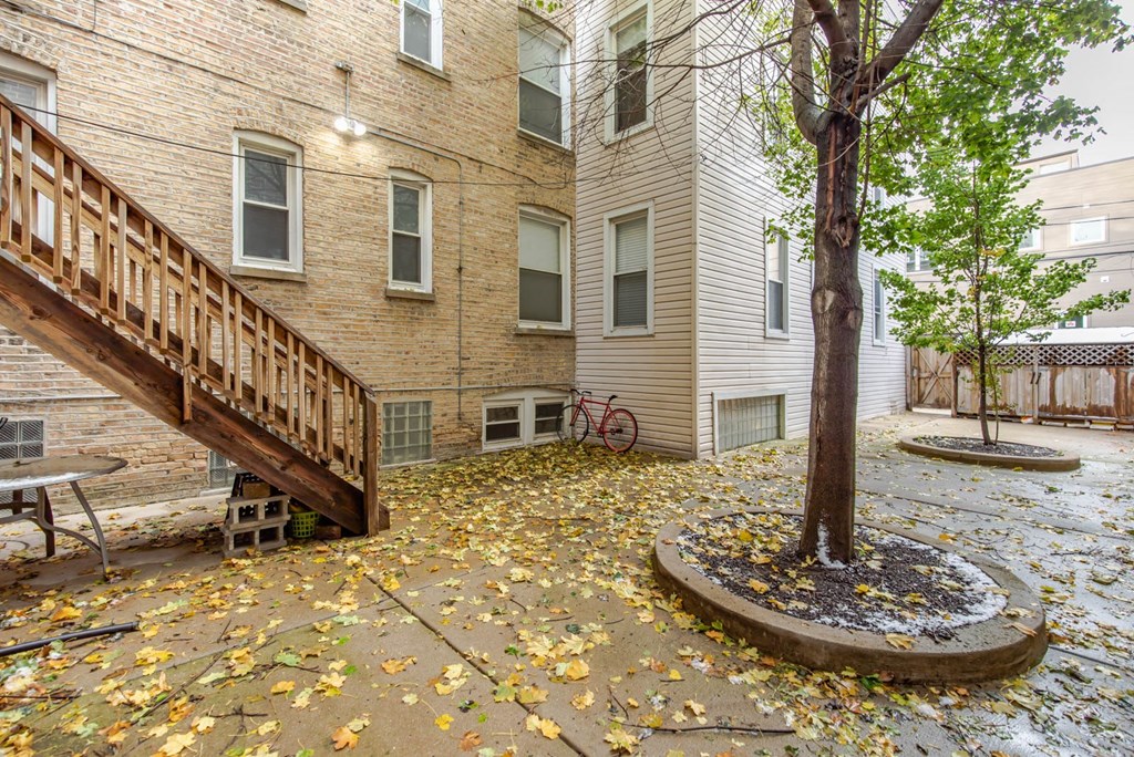 the back yard of a house with a tree and a deck