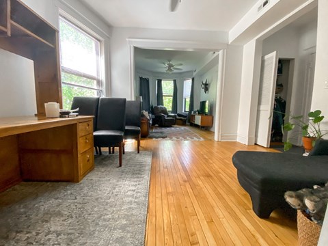 a living room with a hard wood floor and a couch and a desk