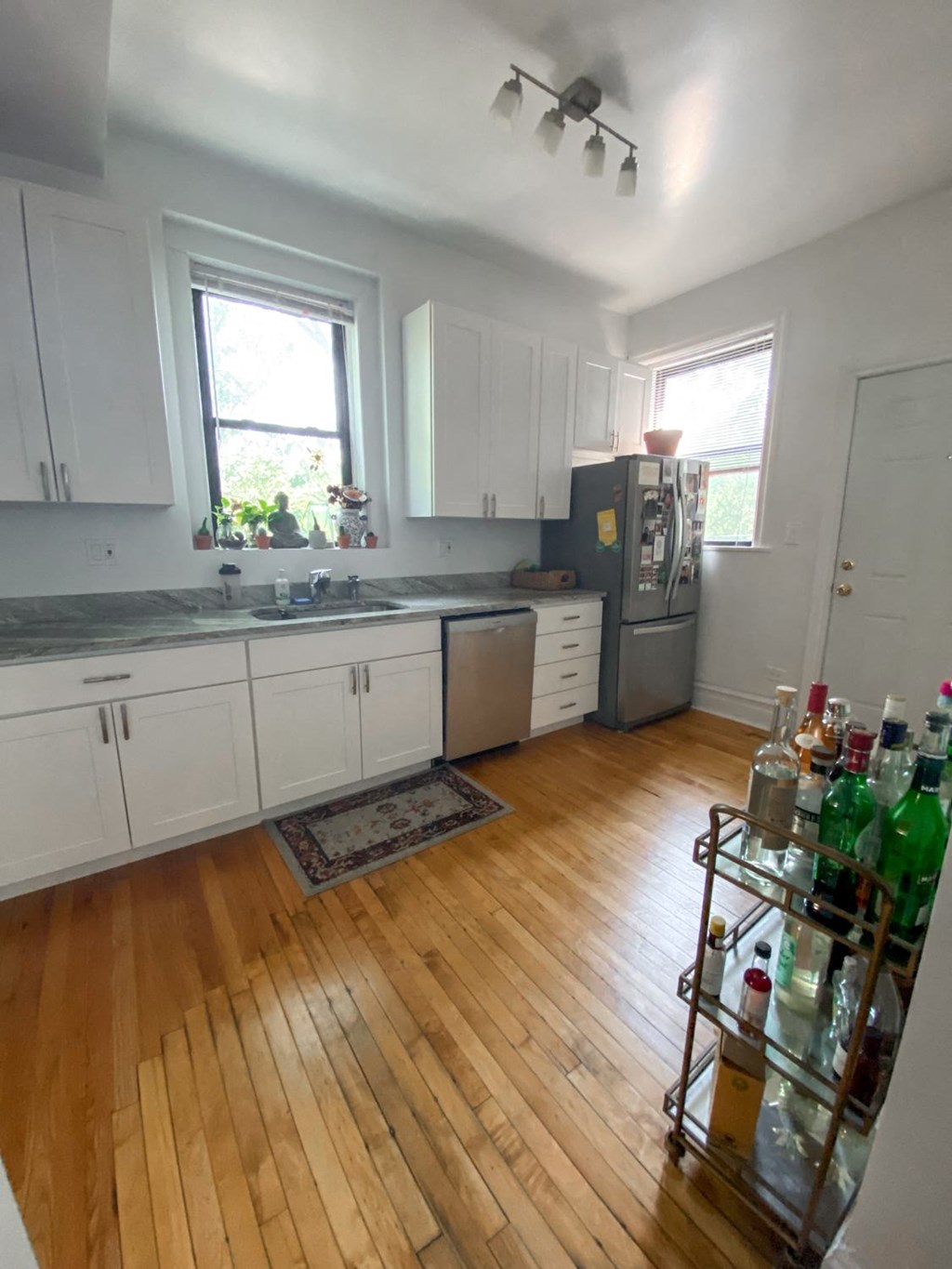 a kitchen with white cabinets and a wood floor