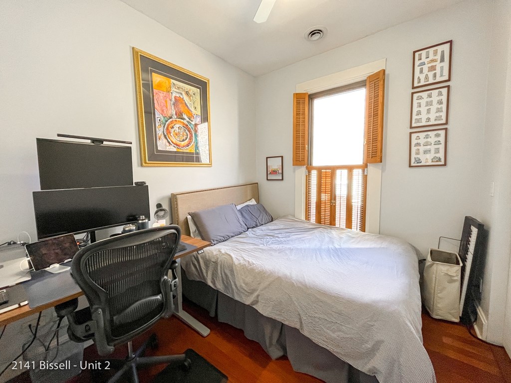 a bedroom with a bed and a desk with a computer
