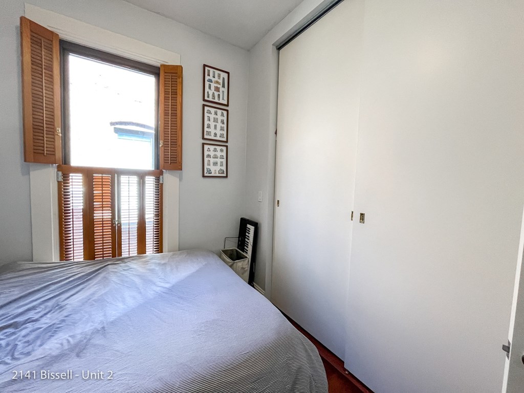 a bedroom with a large window and white walls