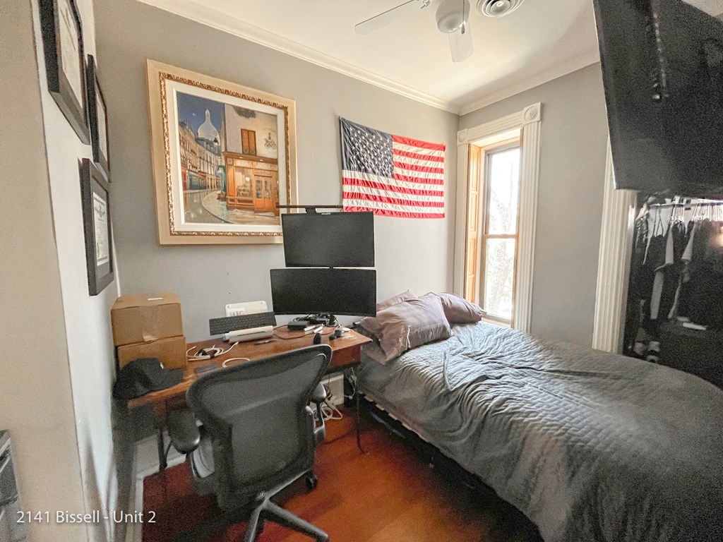 a bedroom with a bed and a desk with a computer