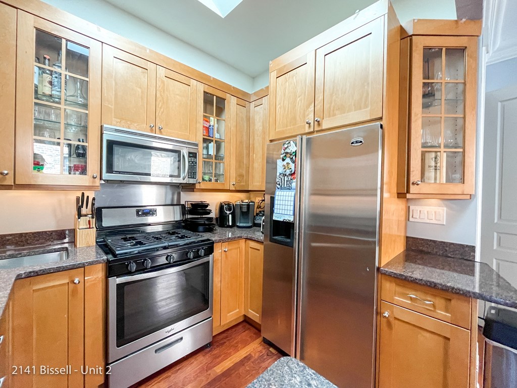 a kitchen with wood cabinets and stainless steel appliances