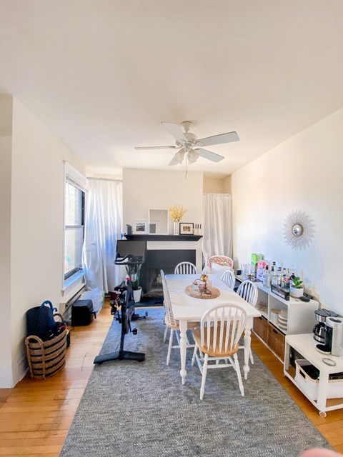 A dining room with a white table and chairs.