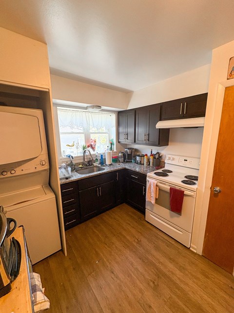 A kitchen with a white oven and black cabinets.