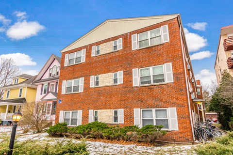 A red brick building with a white window on the second floor.