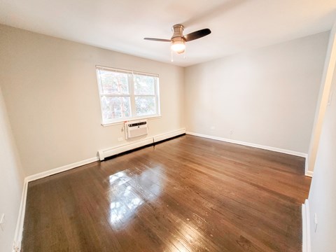 A room with a ceiling fan and a window.