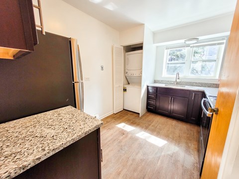 A kitchen with a granite countertop and a refrigerator.