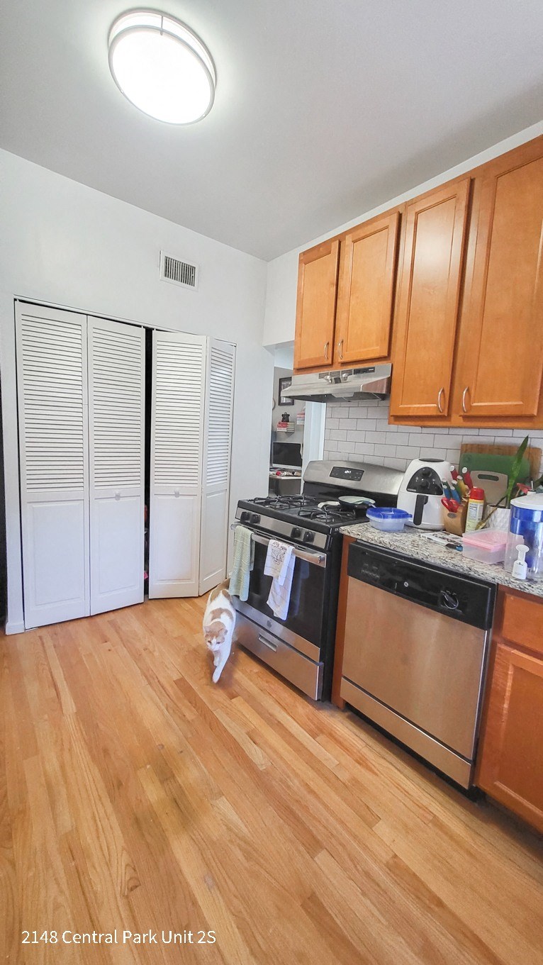 a kitchen with wooden cabinets and a stove and a refrigerator