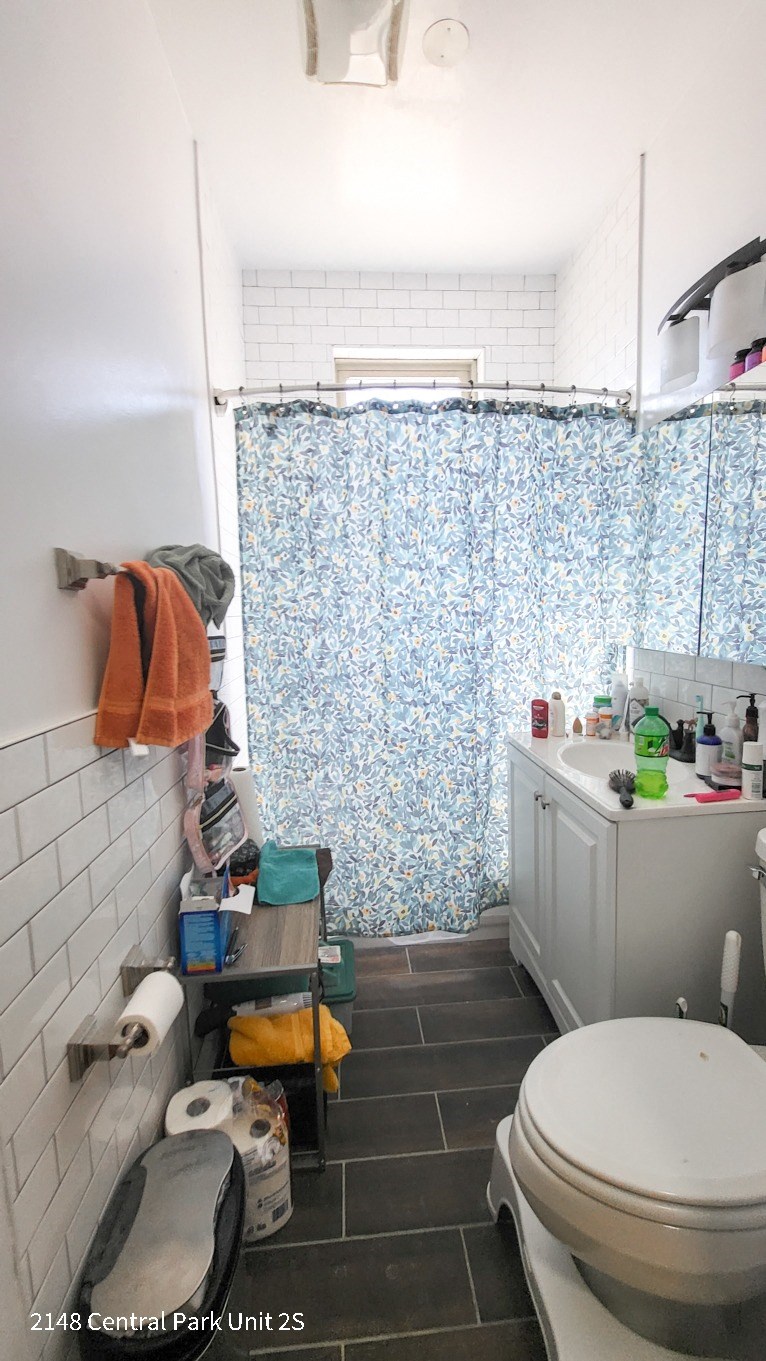a bathroom with a blue and white shower curtain and a toilet