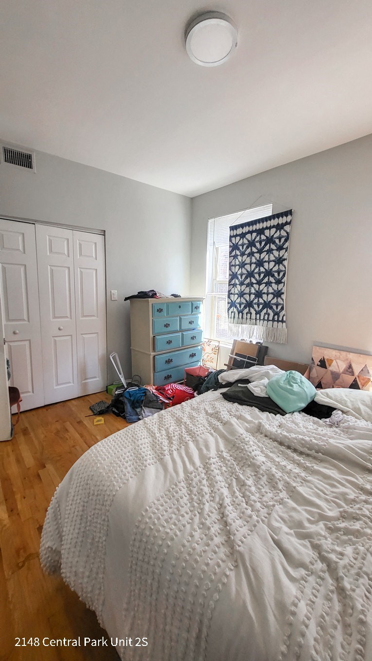 a bedroom with a bed and a dresser and a window