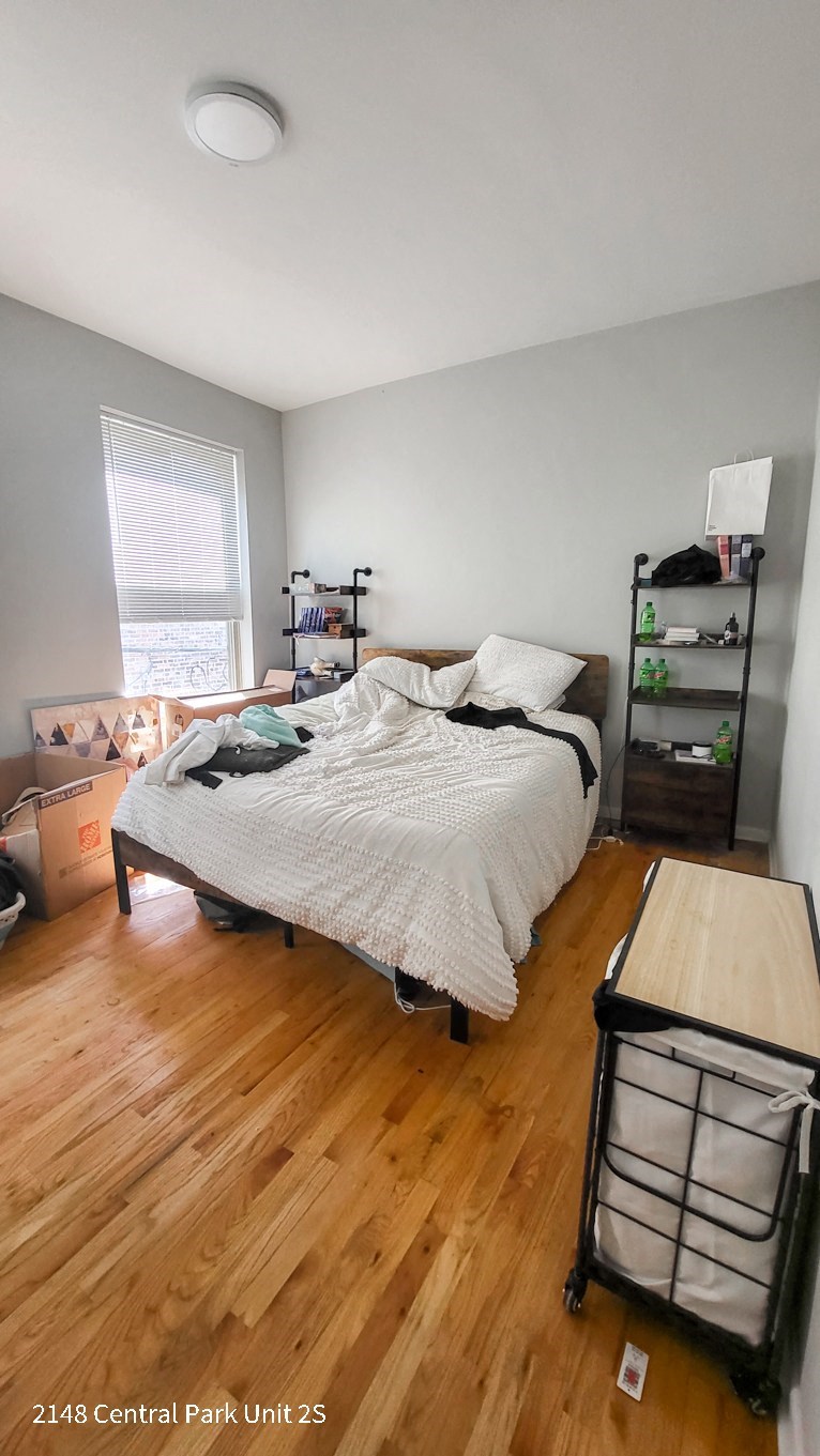 a bedroom with a bed and a wooden floor