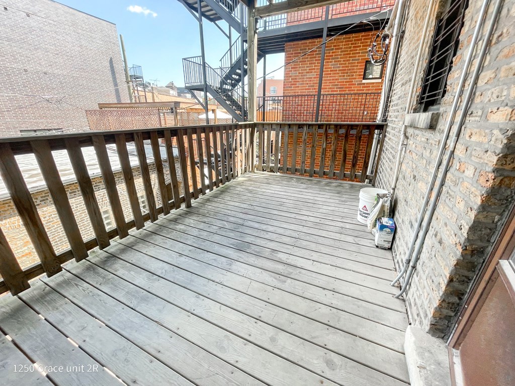 a balcony with a wooden deck and a brick building
