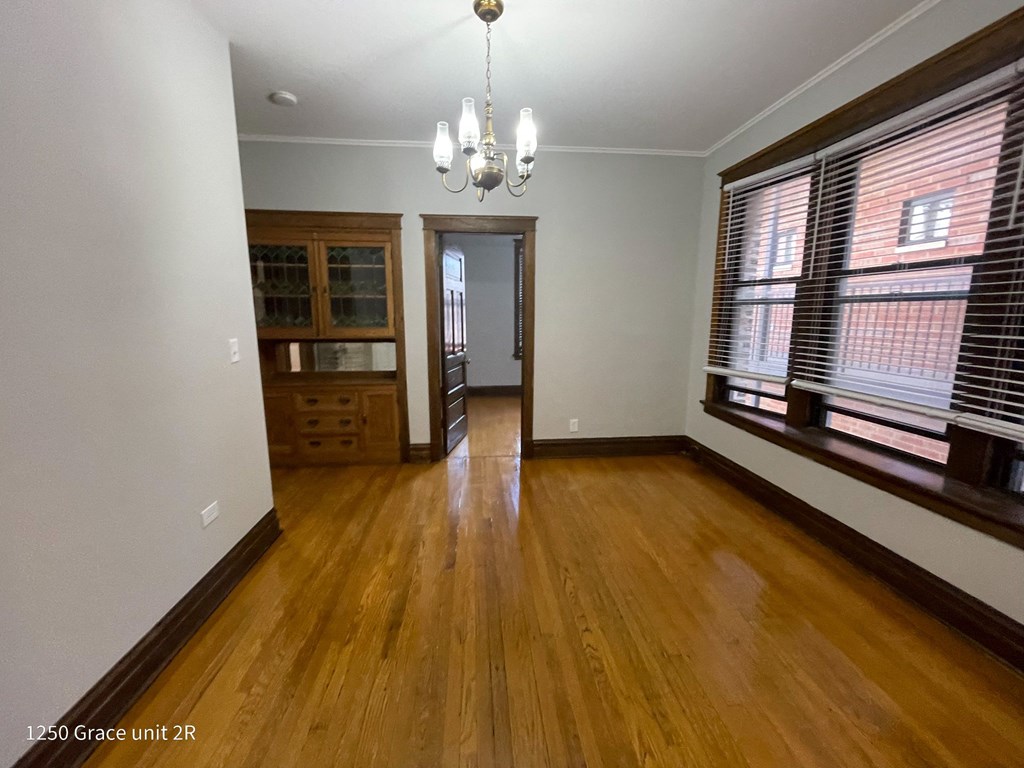 an empty living room with wood floors and large windows