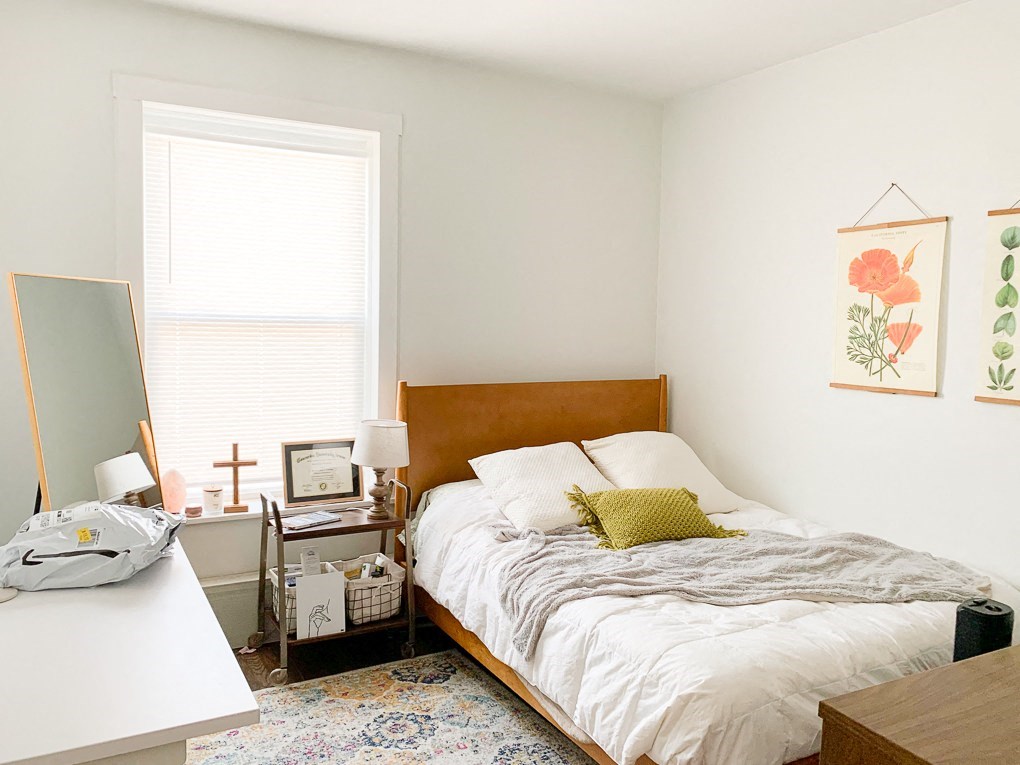 a bedroom with a bed and a desk and a window