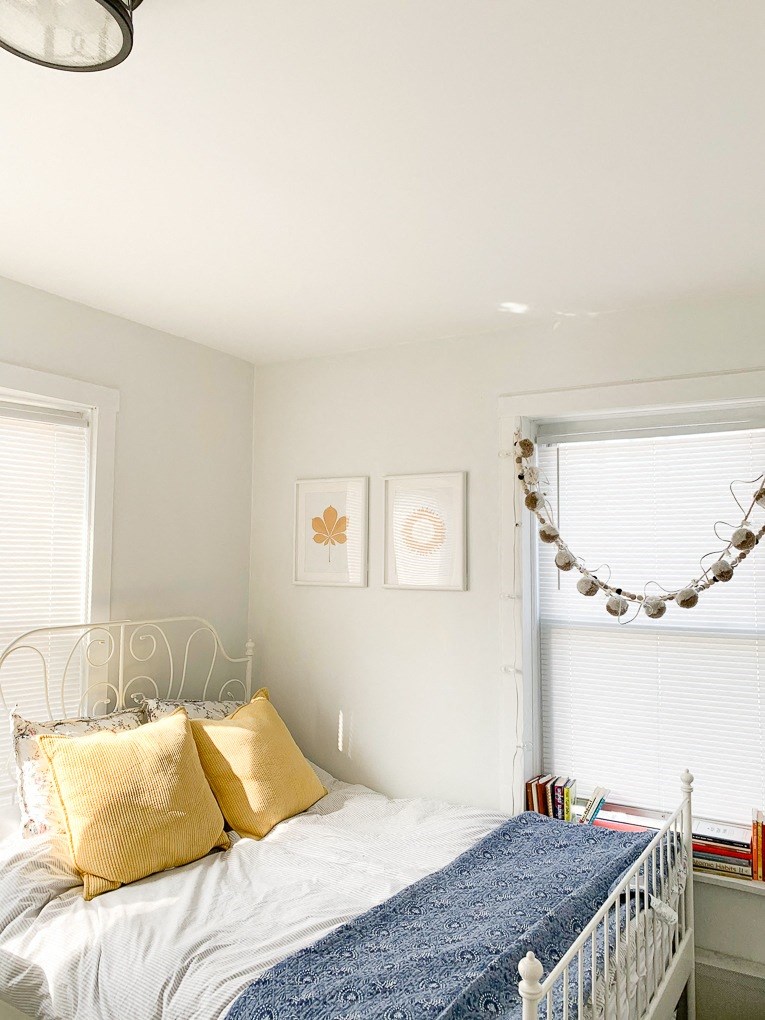 a bedroom with a bed with gold pillows and a blue blanket