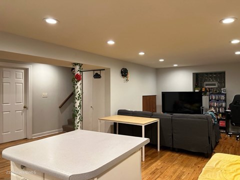A living room with a white table and a grey couch.