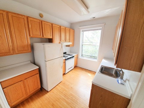 A kitchen with wooden cabinets and a white refrigerator.
