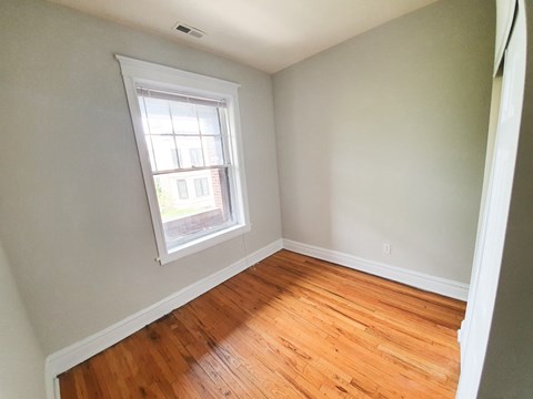 A room with a window and wooden floors.