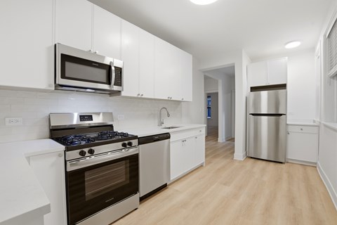 A kitchen with white cabinets and stainless steel appliances.
