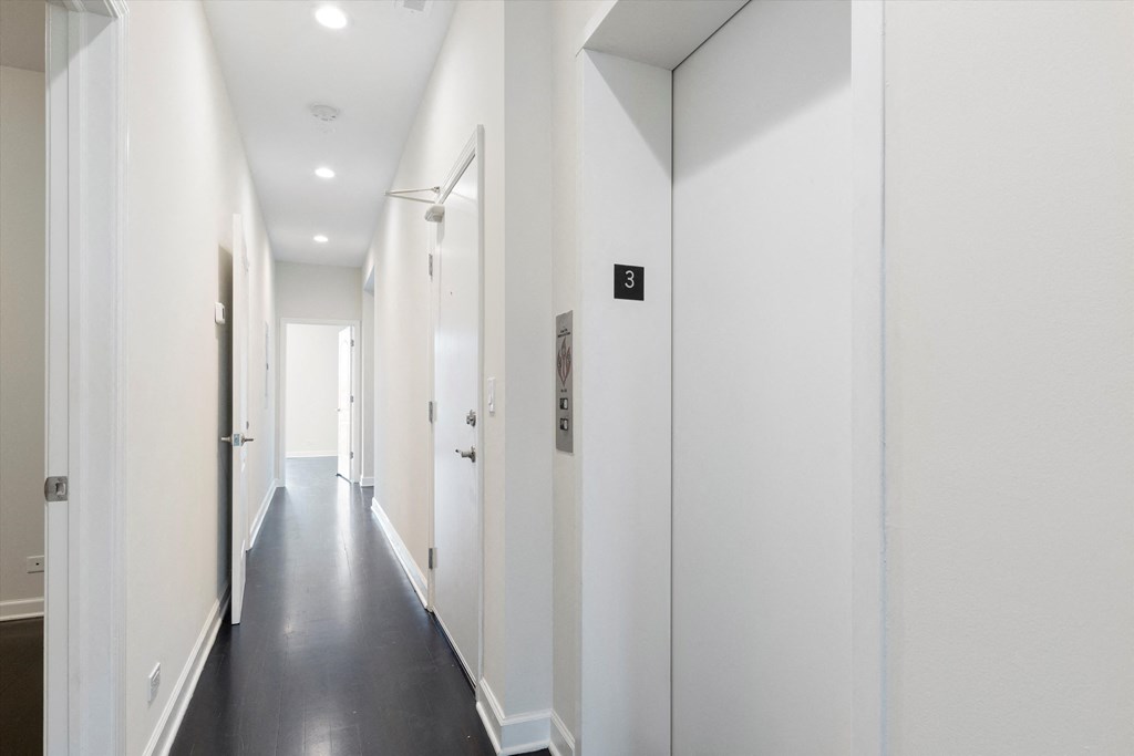 a long corridor with white walls and white ceiling