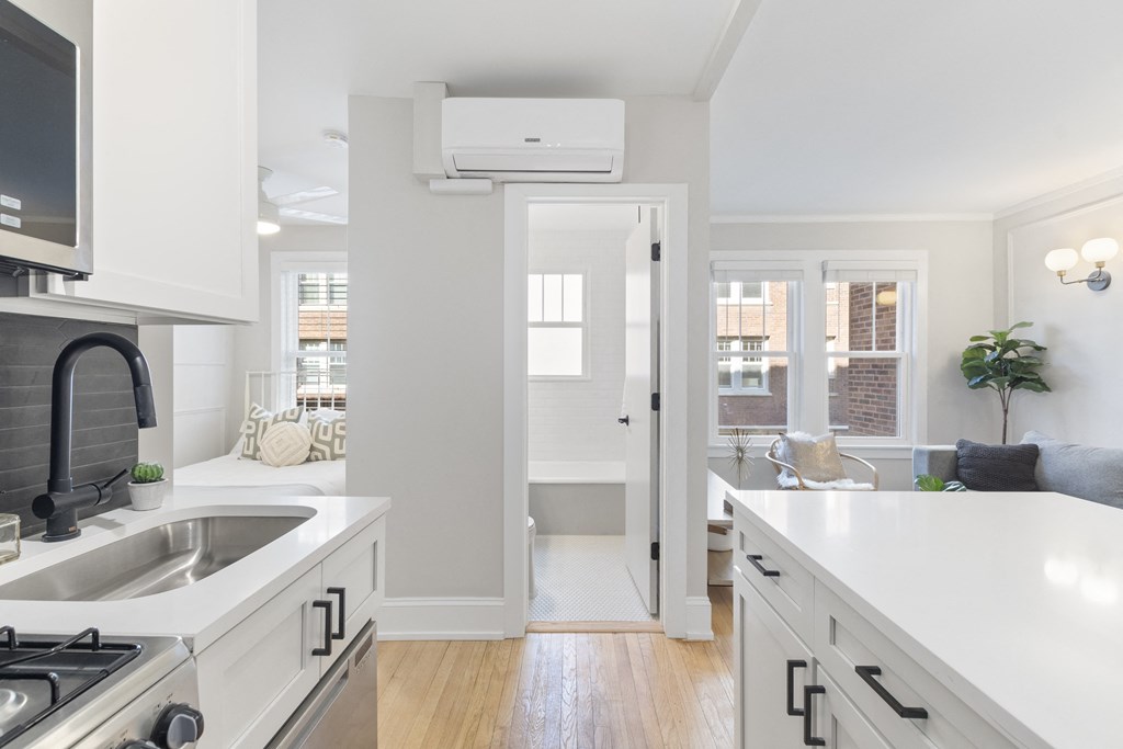a kitchen with white cabinets and a sink and a window
