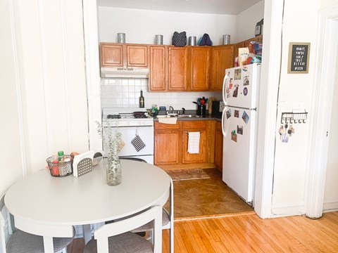 A kitchen with a white fridge and wooden cabinets.