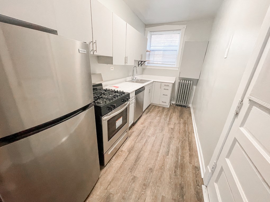 a renovated kitchen with stainless steel appliances and white cabinets