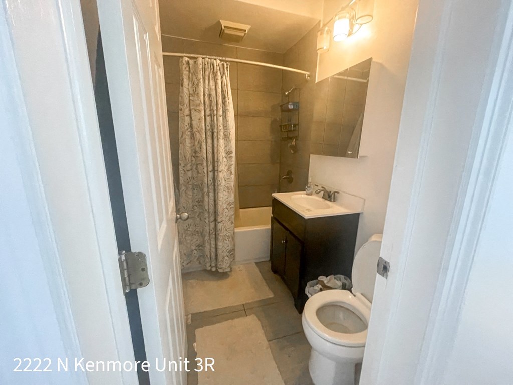 a bathroom with a toilet and a sink and a shower