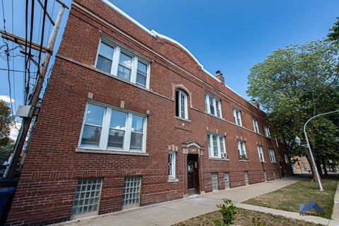 a red brick building with a sidewalk in front of it