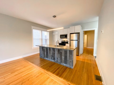 A kitchen with a wooden floor and a grey counter.