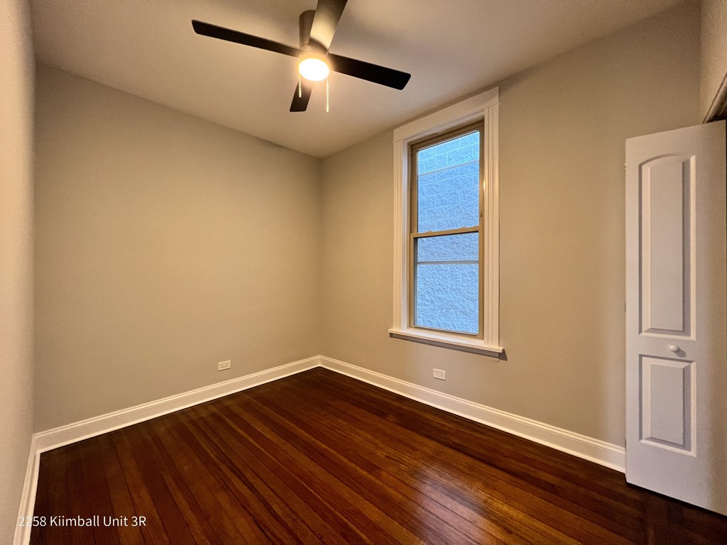 A room with a window and a ceiling fan.