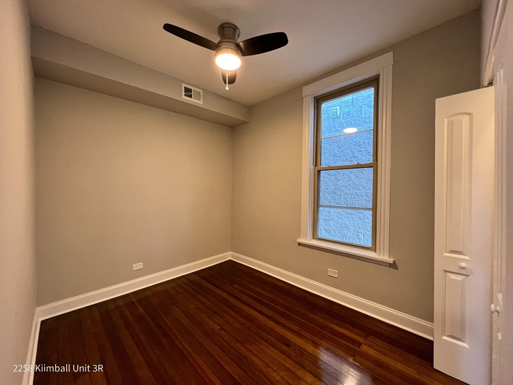 A room with a ceiling fan and a window.