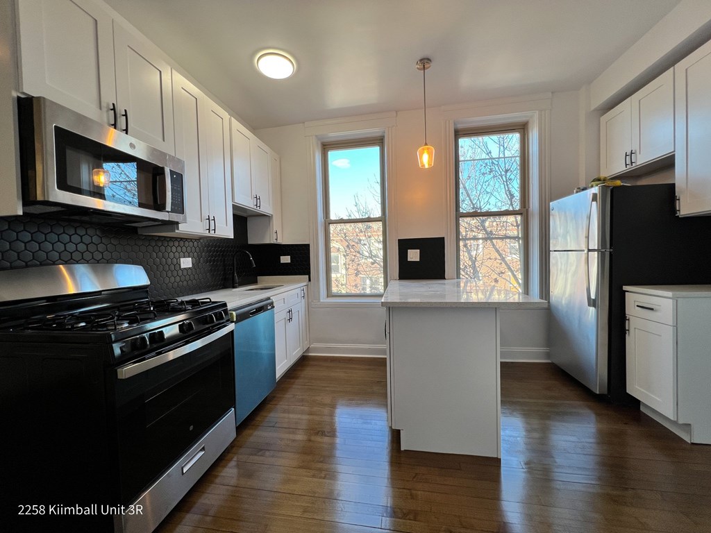A kitchen with black and white appliances and cabinets.