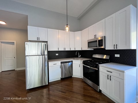 a kitchen with white cabinets and stainless steel appliances