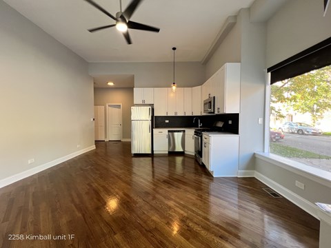 A spacious kitchen with white cabinets and a black countertop.
