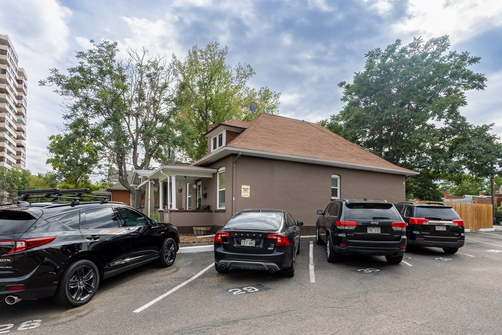 a parking lot with cars parked in front of a house